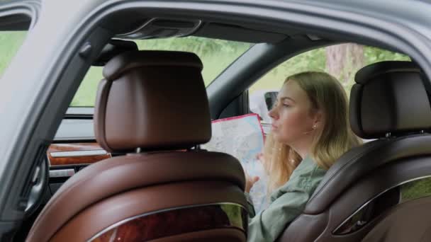 Een Blonde Vrouw Die Auto Zit Route Kaart Controleert Bij — Stockvideo