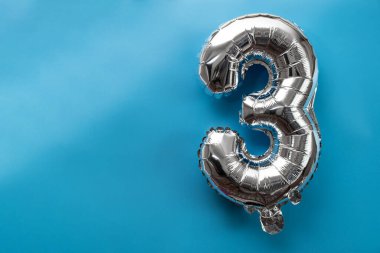 Mavi arka planda 3,3 metalik balon var. Kutlama kartı gümüş folyo balon numarası Mutlu yıllar tatil konsepti. Uzayı metin için kopyala. Kutlama partisi dekorasyonu.