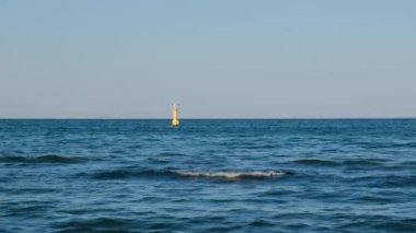 Sarı Deniz feneri mavi deniz hattında. Baltık Denizi 'nde güneşli bir günde dalgalar. Gdansk Polonya. Kıyı şeridi