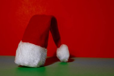 İzometrik yeşil arka planda Noel Baba şapkası. Metnin için alanı kopyala. Reklam için hazırlan. Tatil Noel kompozisyonu. Minimalist tebrik kartı. Yaratıcı 