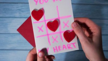 Sevgililer Günü için kartla zarf açıyorum. Kalp atışlarımı ve Tic Tac toe kartpostal oyunumu kazandığını mesaj atarım, tebrik kartı. El yapımı sevgililer günü tebrik kartı. Kendi ellerinle.