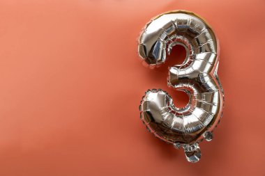 Pembe arka planda 3 adet metalik balon var. Kutlama kartı gümüş folyo balon numarası Mutlu yıllar tatil konsepti. Uzayı metin için kopyala. Kutlama partisi dekorasyonu.