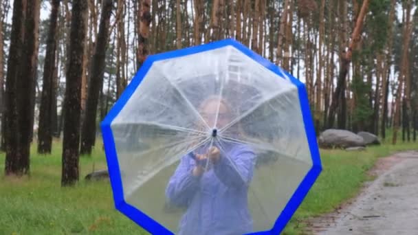 Ağır Çekimde Genç Bir Kadın Ormanda Şeffaf Mavi Şemsiyeyi Açar — Stok video