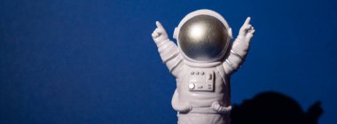 Renkli mavi arkaplan fotokopi uzayındaki plastik oyuncak astronot. Dünya dışı seyahat kavramı, özel uzay adamı ticari uçuşları. Uzay görevleri ve Sürdürülebilirlik