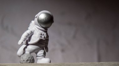 Plastic toy figure astronaut on moon concrete background Copy space. Concept of out of earth travel, private spaceman commercial flights. Space missions and Sustainability