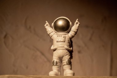 Plastic toy figure astronaut on moon concrete background Copy space. Concept of out of earth travel, private spaceman commercial flights. Space missions and Sustainability