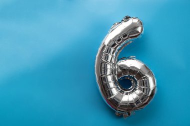 Mavi arka planda 6 metalik balon var. Kutlama kartı gümüş folyo balon numarası Mutlu yıllar tatil konsepti. Uzayı metin için kopyala. Kutlama partisi dekorasyonu.