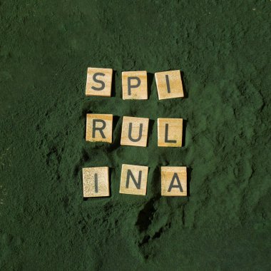 SPIRULINA deniz yosunlarının yeşil arka planında klorella harfi. Organik mavi-yeşil alg spirulina tozu. Doğal ilacın sağlıklı faydaları. Alternatif ilaç mineral gıda antioksidan