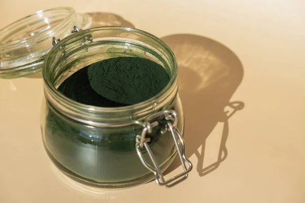 Stock image Organic blue-green algae spirulina powder food in glass jar. Health benefits of spirulina chlorella. Vitamins and minerals to diet. Detox dietary supplement Seaweed superfood concept