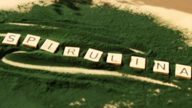 Alg süper yiyecek tozunun arka planında SPIRULINA klorellası olan tahta bloklar. Sağlıklı fayda desteği ve vegan antioksidan sağlıklı yeme konsepti 