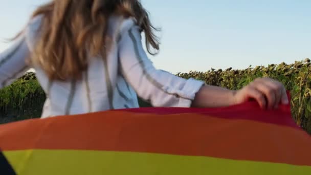 Jonge Vrouw Rennen Het Veld Met Rainbow Lgbtqia Vlag Zwaaien — Stockvideo