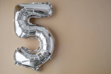 Bej renksiz arka planda 5.5 metalik balon. Kutlama kartı gümüş folyo balon numarası Mutlu yıllar tatil konsepti. Uzayı metin için kopyala. Kutlama partisi dekorasyonu.