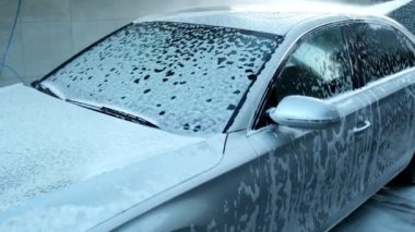 Dokunulmaz araba yıkamada lüks gümüş araba yıkama. Köpüklü araba yıkama ve yüksek basınçlı su. Arabanın detaylarını temizliyorum. Kentsel çevrede temizlik ve düzen