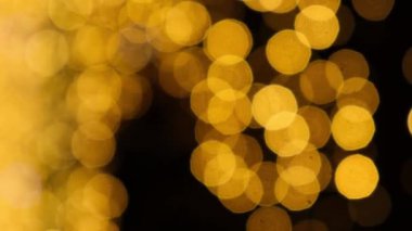Defocused pulsating colorful lights bokeh against dark background. Abstract bokeh holiday background. Presentation Party Bokeh Effect. Yellow and orange Christmas and New Year colors