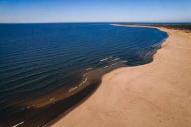 Dalgaların, deniz kıyılarının insansız hava görüntüsü. Kumsallar ve kumullar, sakin deniz dalgaları insansız hava aracıyla ele geçirilen doğa manzarası. Polonya 'da turizm