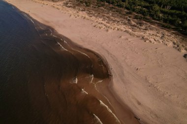 Dalgaların, deniz kıyılarının insansız hava görüntüsü. Kumsallar ve kumullar, sakin deniz dalgaları insansız hava aracıyla ele geçirilen doğa manzarası. Polonya 'da turizm