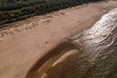 Dalgaların, deniz kıyılarının insansız hava görüntüsü. Kumsallar ve kumullar, sakin deniz dalgaları insansız hava aracıyla ele geçirilen doğa manzarası. Polonya 'da turizm