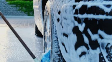 Dokunulmaz araba yıkamada lüks siyah araba yıkama. Arabanın detaylarını temizliyorum. Köpüklü araba yıkama ve yüksek basınçlı su. Kentsel çevrede temizlik ve düzen