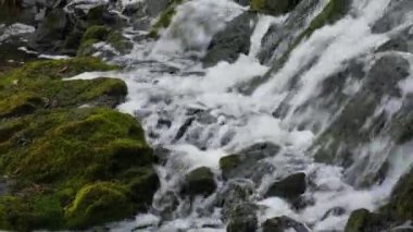Akan şelalenin yavaş çekim görüntüleri suyun hareketini gösteriyor. Dağ şelalesi nehirlerin ve derelerin çağlayan kayalarının üzerine su döker. Ekosisteme ve yenilenebilir enerjiye saygı