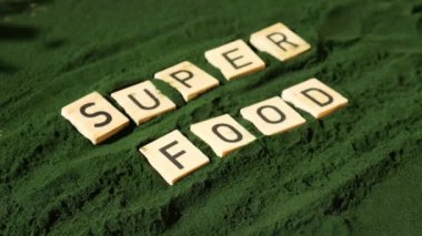 Tahta bloklar, alg süper yiyecek tozunun arka planında SUPERFOOD klorellası var. Sağlıklı fayda desteği ve vegan antioksidan sağlıklı yeme konsepti 