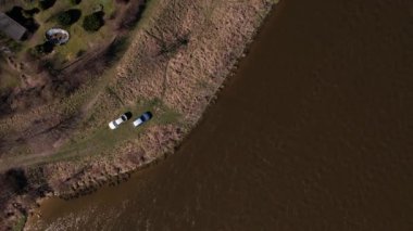 Nehir kıyısındaki iki arabanın hava görüntüsü. Açık hava aktivitesi kavramı doğayla uyum içinde zaman geçirir. Uzaklaşıyorum. Yerel seyahat