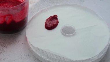 Tanınmayan bir kadın ev yapımı lezzetli ev yapımı organik tatlı farklı meyvelerden yapılmış. Ev yapımı pastil hazırlanıyor. Ev yapımı vegan kurutulmuş meyve derisi kavramı. Sağlıklı