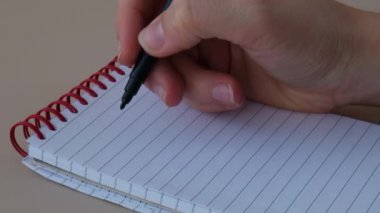 Defterde ev giderleri yazan bir kadın. Bir dolar nakit para elektrik, benzin ve su faturalarını sayıyor. Verimli Tüketim ve Ekonomi kavramı. Harcama alışkanlıkları