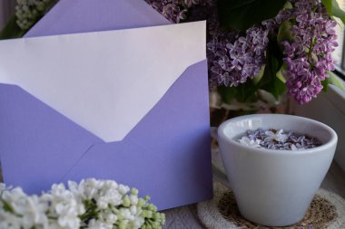 Boş zarf kağıdının fotokopisini çek. Beyaz bardakta siyah çay ve aromatik leylak çiçekleri olsun. Bahar kompozisyonu bir fincan leylak çayı içerken mor leylak dalları çiçek açar.