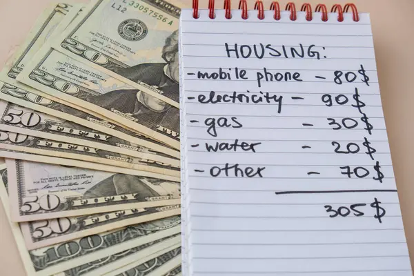 stock image Dollar cash money with notebook handwritten housing expenses. Counting bills for electricity, gas, water. Concept of Efficient Consumption and Economy. Spending habits