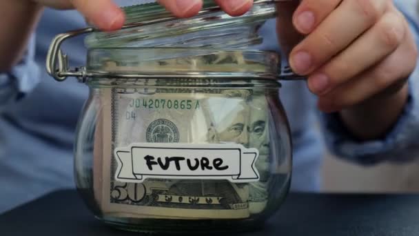 Felismerhetetlen Pénzt Vesz Pénztakarékos Üvegből Ami Tele Van Dollárbankjegyekkel Jövőbeli — Stock videók