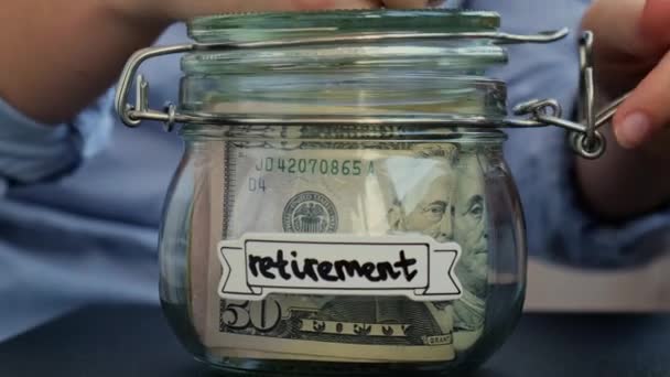 Неузнаваемая Женщина Добавляет Деньги Сбережению Денег Стеклянную Банкноту Долларами Retirement — стоковое видео