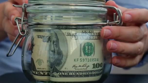 認識できない女性は テキストPensionでアメリカの通貨ドル紙幣でいっぱいのガラス瓶を回します お金を節約する準備 適度な消費と経済 お金の収集について — ストック動画
