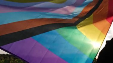 Gökkuşağı LGBTQIA bayrağı, arka planda ipek malzemeden yapılan rüzgarda dalgalanıyor. LGBTQ gurur ayının sembolü. Eşit haklar. Barış ve özgürlük kavramı