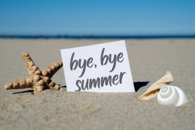 Elveda, deniz yıldızı deniz kabuğu yaz tatili dekorunun arka planında kağıt tebrik kartı üzerine yazılmış bir yazı. Kumsalın güneş kıyısı. Tatil konsepti kartpostalı. Kaçmak Seyahat İş Konsepti