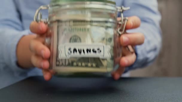 Kobiece Ręce Stół Oszczędzanie Pieniędzy Szklanym Słoiku Wypełnionym Banknotami Dolarowymi — Wideo stockowe