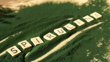 SPIRULINA deniz yosunlarının yeşil arka planında klorella harfi. Organik mavi-yeşil alg spirulina tozu. Doğal ilacın sağlıklı faydaları. Alternatif ilaç mineral gıda antioksidan