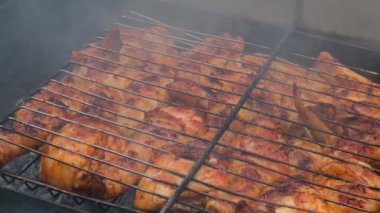 Barbeküde ızgara ızgarada kızarmış tavuk. Baharat taze ızgara tavuk kanatlarına dökülüyor. Yaz partisi yemekleri. Barbekü Sulu ızgara ızgarada kızarmış tavuk budu. 