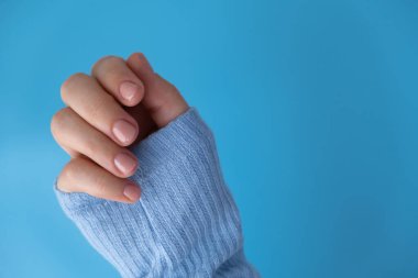Mavi arka planda zarif, çıplak bej kadın tırnakları. Modern moda stil güzel manikür. Güzel pastel tırnak minimalistik güzellik tasarımı konsepti. Jel tırnaklar. Cilt bakımı. Güzellik uzmanı