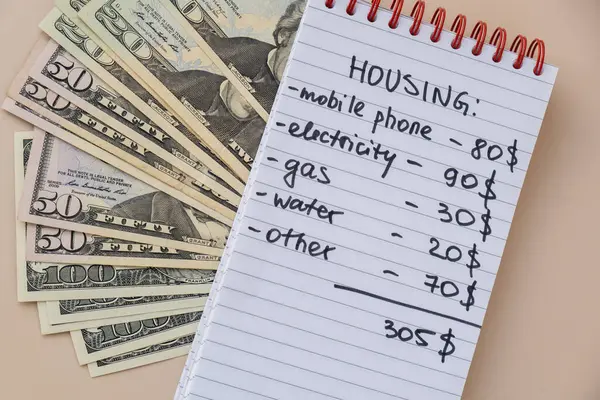 stock image Counting expenses bills on housing electricity, gas, water. Banknotes of dollar cash around. High prices for energy inflation crisis. Cut back on spending. Savings rate