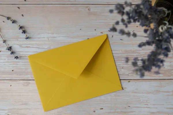 Empty yellow envelope paper template mock up. Copy space for your text. Lavender flower. Greeting or invitation card blank with envelope. Top view, flat lay
