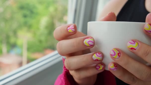 色彩艳丽的夏季女性指甲上挂着一杯白咖啡或茶 时尚时髦的美发美发 美容美发最简约的设计理念 凝胶钉 — 图库视频影像