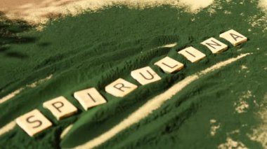 Alg süper yiyecek tozunun arka planında SPIRULINA klorellası olan tahta bloklar. Sağlıklı fayda desteği ve vegan antioksidan sağlıklı yeme konsepti 