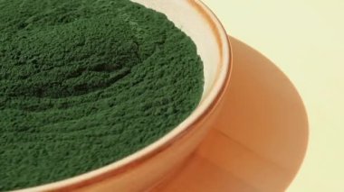 Doğal doğal yeşil spirulina alg tozu nötr arka planda kasede dönüyor. Chlorella deniz yosunu vejetaryen süper gıda kaynağı ve detoks. Boşluğu kopyala Sağlıklı besleyici antioksidan kavramı 