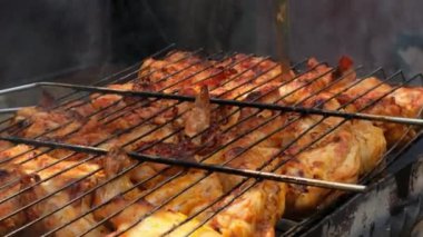Barbeküde ızgara ızgarada kızarmış tavuk. Baharat taze ızgara tavuk kanatlarına dökülüyor. Yaz partisi yemekleri. Barbekü Sulu ızgara ızgarada kızarmış tavuk budu. 