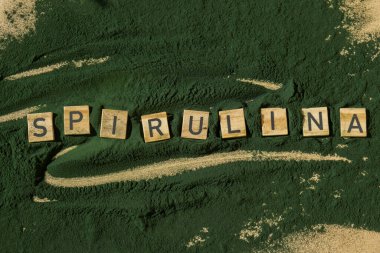 SPIRULINA deniz yosunlarının yeşil arka planında klorella harfi. Organik mavi-yeşil alg spirulina tozu. Doğal ilacın sağlıklı faydaları. Alternatif ilaç mineral gıda antioksidan