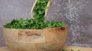 Ahşap kasede tahta kaşıkla kuru maydanoz baharatı. Yemek pişirmek için ev yapımı otlar ve baharatlar. Taze kurutulmuş aromatik doğal gıda malzemeleri.. 