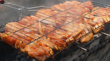 Barbeküde ızgara ızgarada kızarmış tavuk. Baharat taze ızgara tavuk kanatlarına dökülüyor. Yaz partisi yemekleri. Barbekü Sulu ızgara ızgarada kızarmış tavuk budu. 