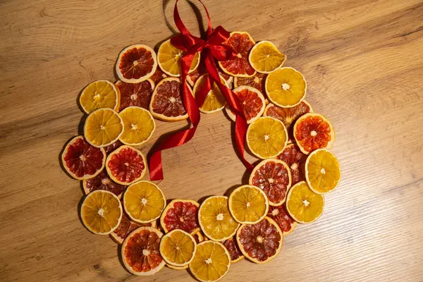 Stock image Step 4 Step by step instruction of making handmade Christmas wreath made of dry fruits oranges and grapefruits. Female hands creating craft homemade decor. New year celebration. Winter holidays