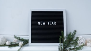 Motion animasyonunu durdurun. Yeni Yıl. Siyah harflerle yazılmış, el yapımı, minimalist bir Noel dekoru. Yeni yıl kararları hedefler. Gösterişsiz festival Planlama ve hedef belirleme kavramı