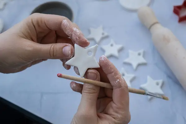 stock image Christmas star Creator is using white air dry clay for making decor to Christmas tree holiday. Creating hobby recreation activity that involves fingers. DIY crafting Modern art 